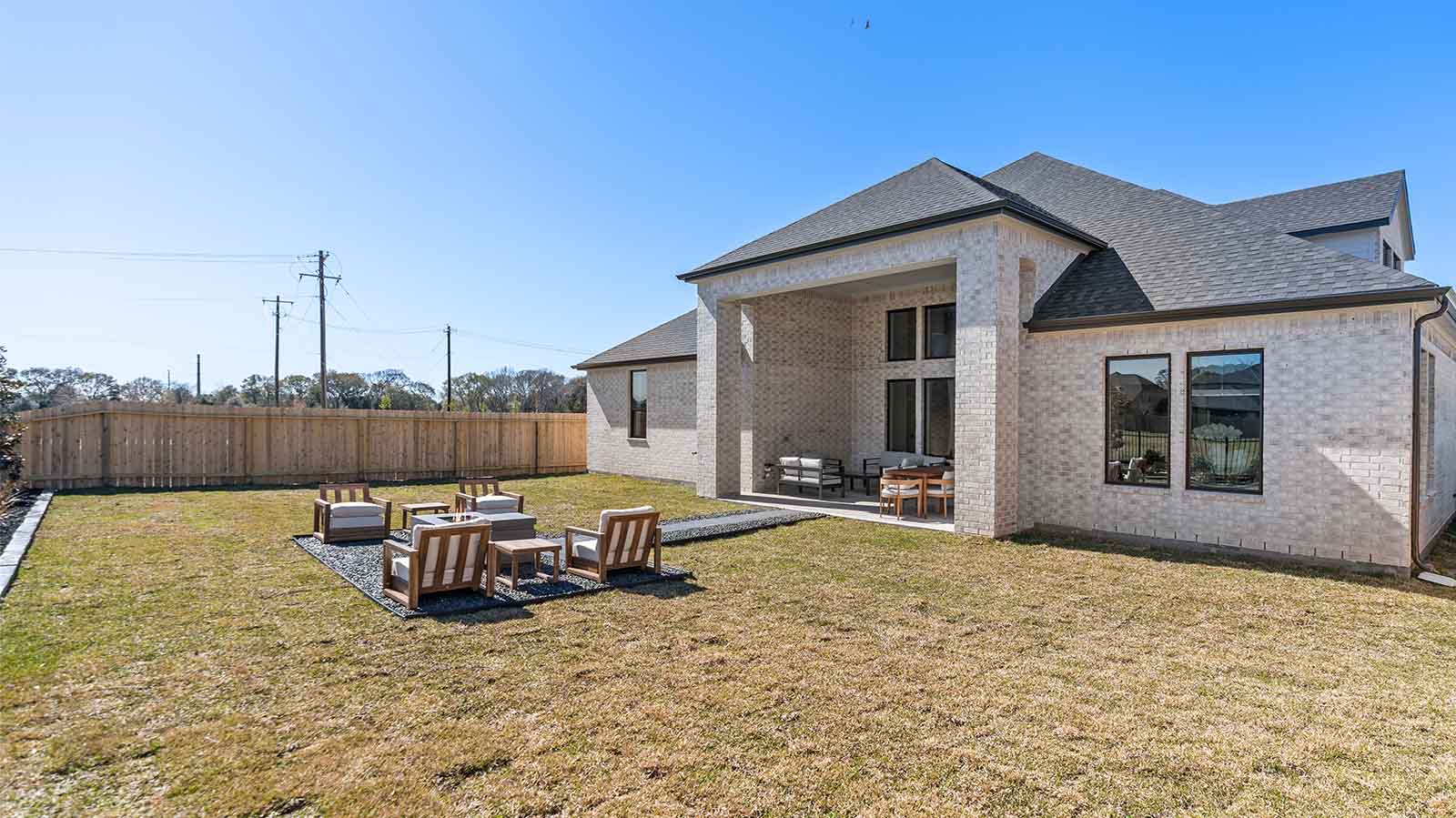 Large fenced-in backyard with a covered patio, perfect for outdoor entertaining.