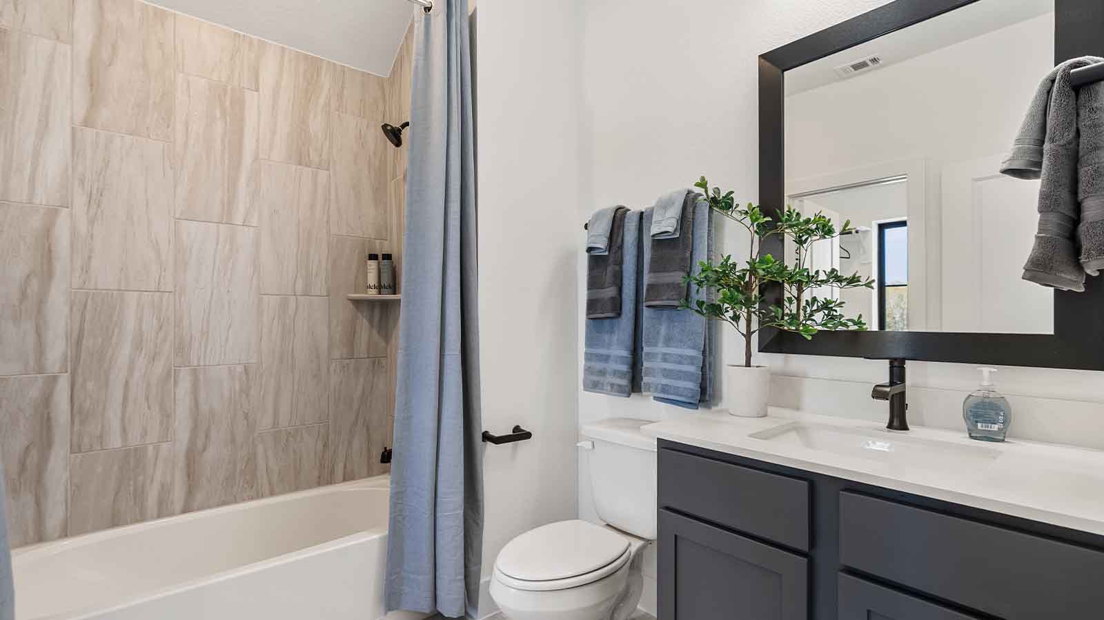 A well-designed bathroom equipped with quartz countertops, a standing tub, and a single vanity.