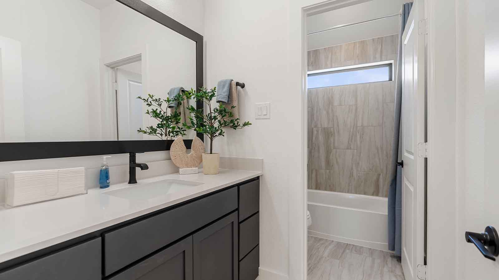 A secondary bathroom with a standing tub, one sink vanity, and a window for natural lighting
