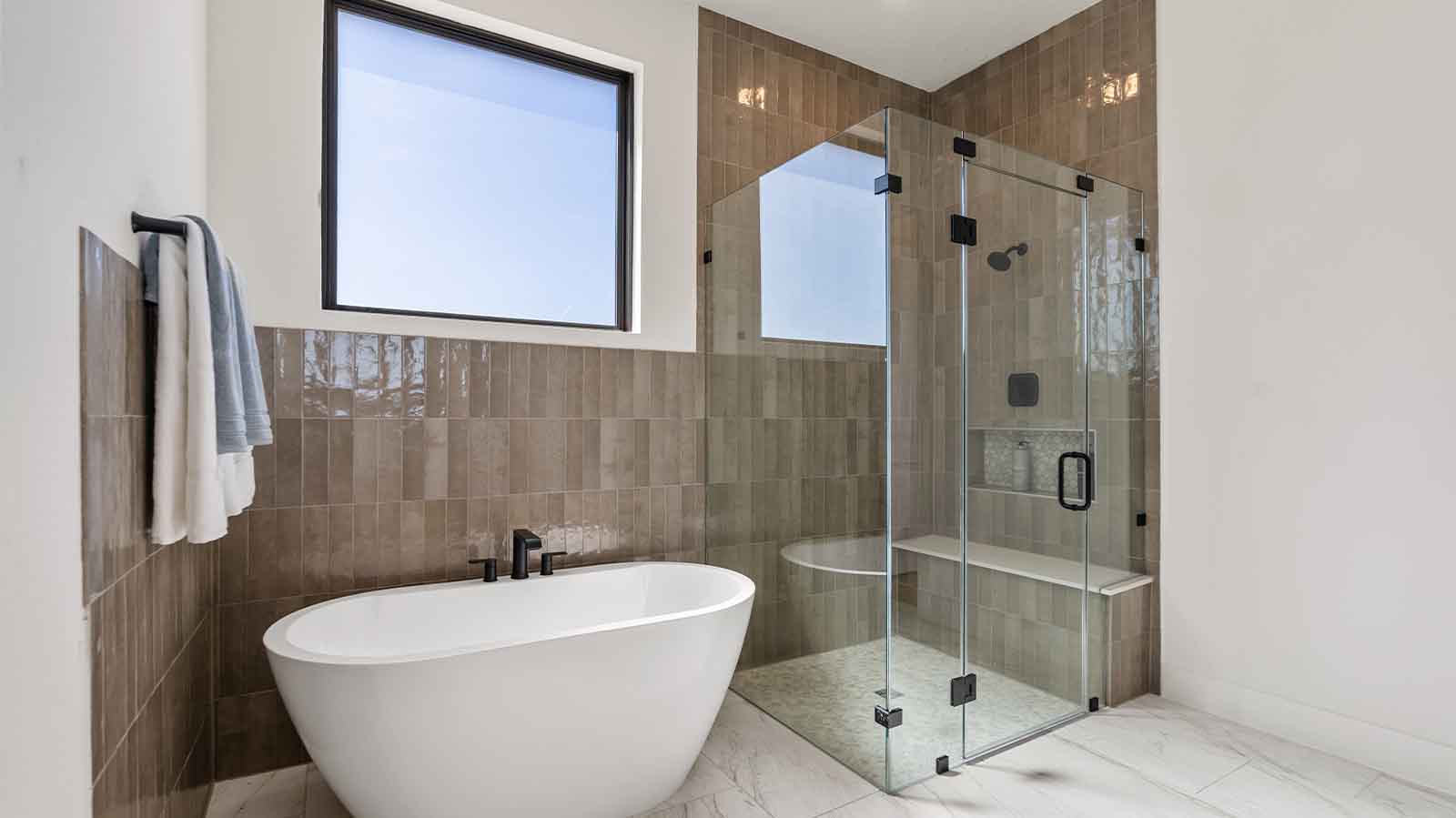 Primary bathroom with a glass-enclosed standing shower and separate soaking tub.