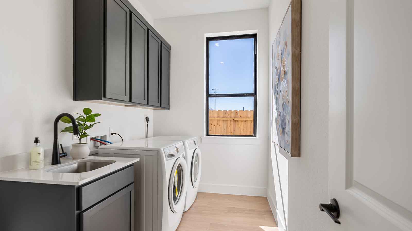 A laundry room featuring a washer and dryer, neatly arranged with ample space for laundry tasks, and storage.