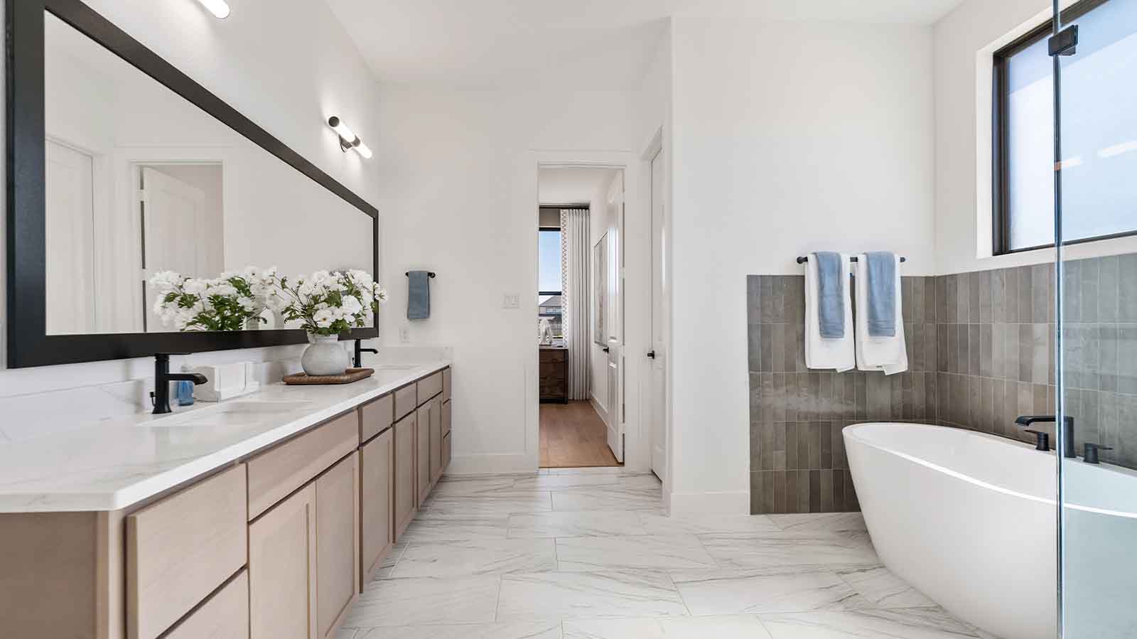primary bathroom with two sinks and one window