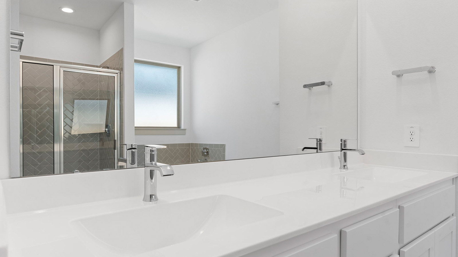 Primary bathroom vanity with two sinks and a large mirror