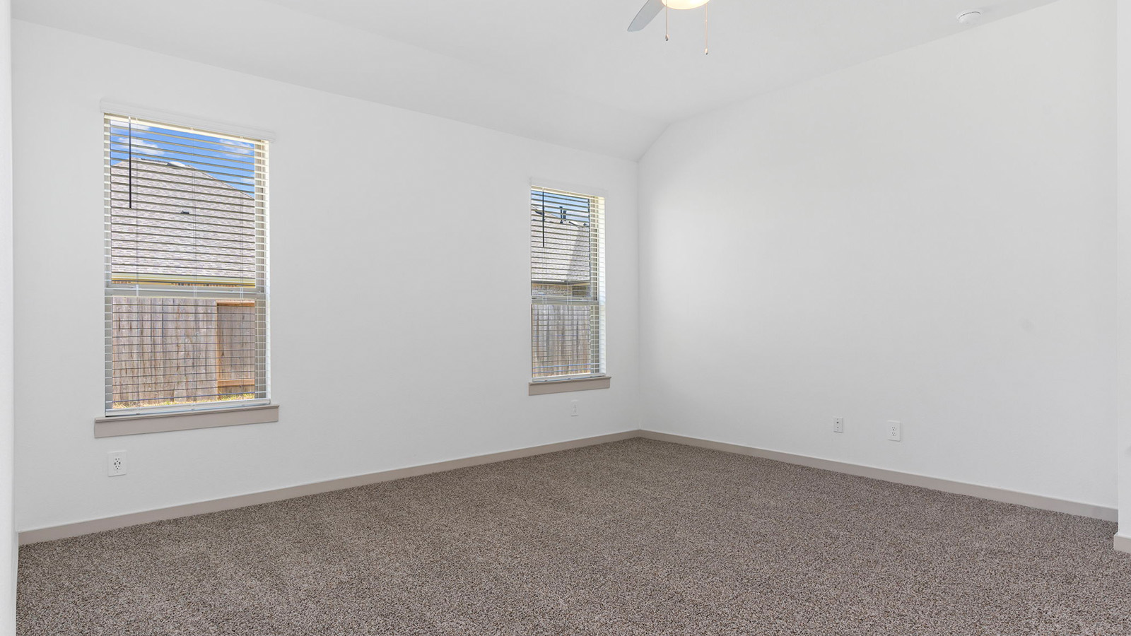 Spacious primary bedroom with two large windows