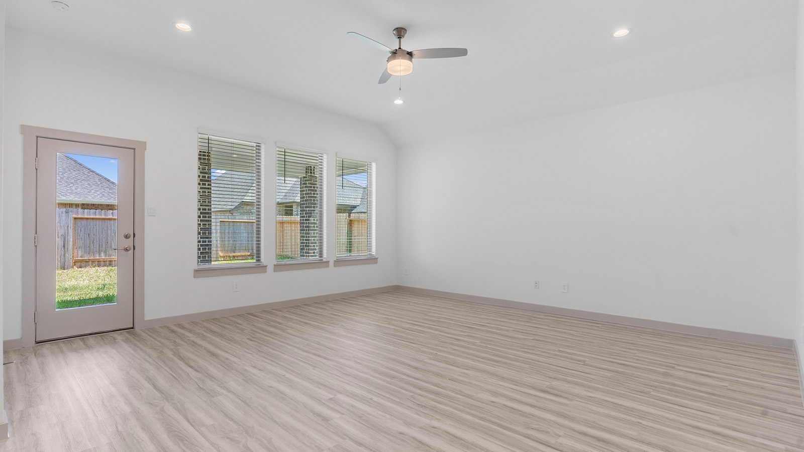 Living room with a back patio door and three large windows