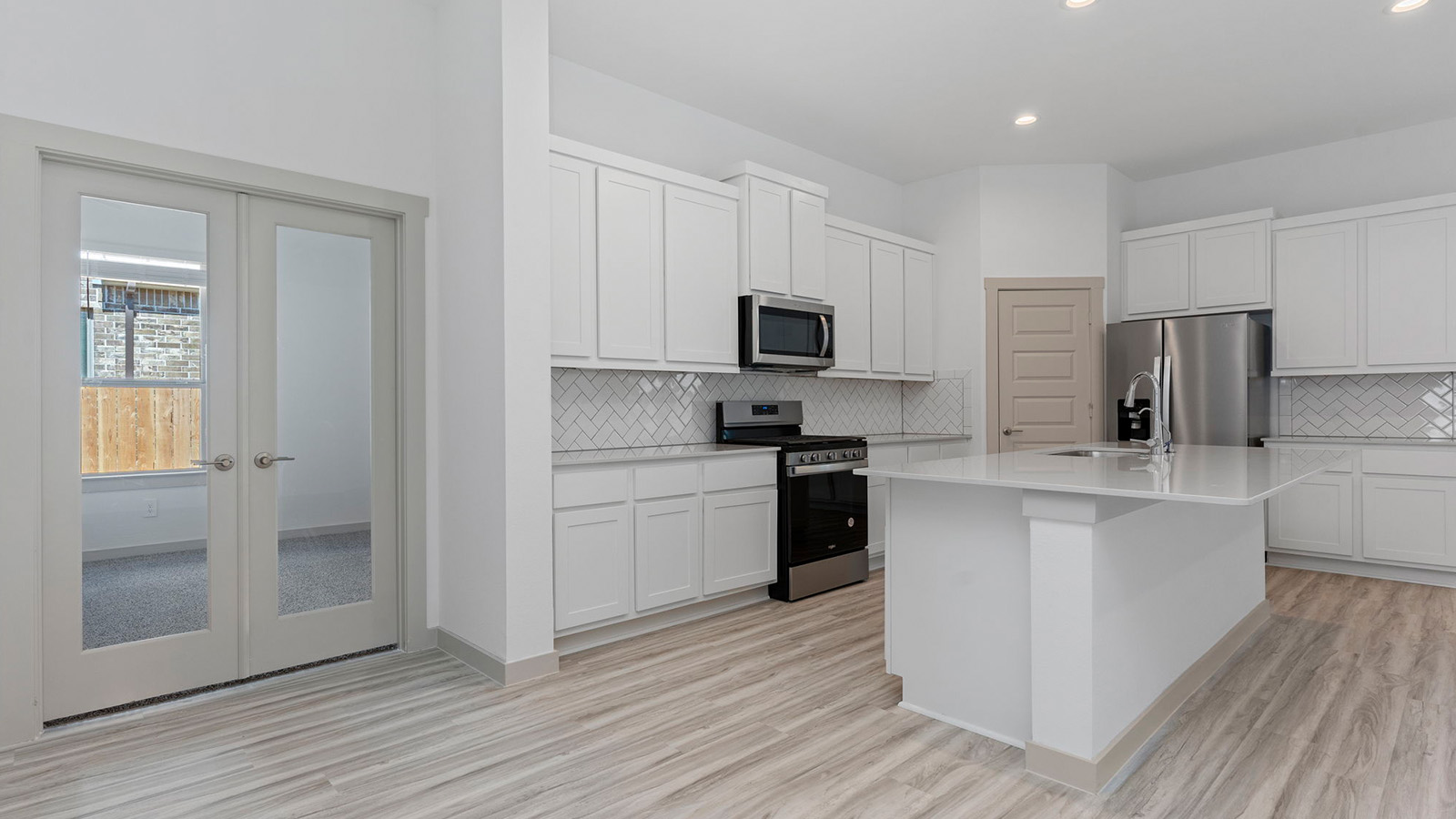 Open concept kitchen with back patio French doors