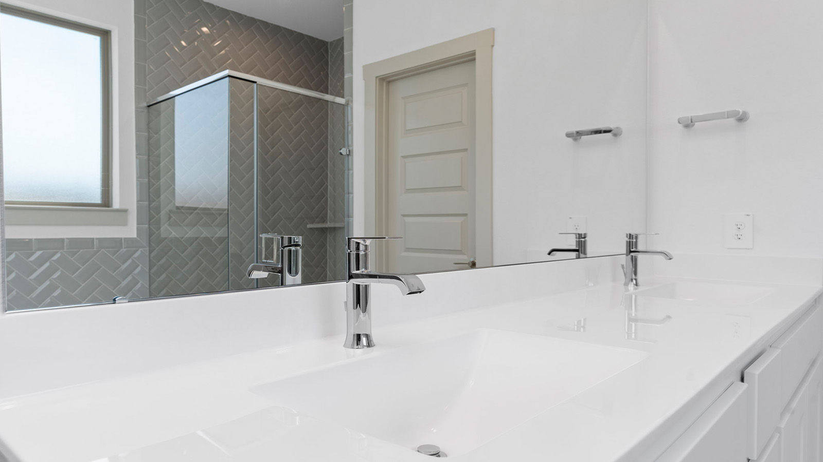 Primary bathroom vanity with two sinks and a large mirror