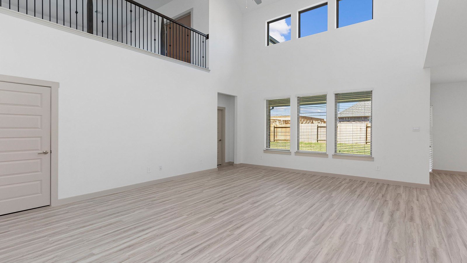Spacious living room with high ceilings and four large windows