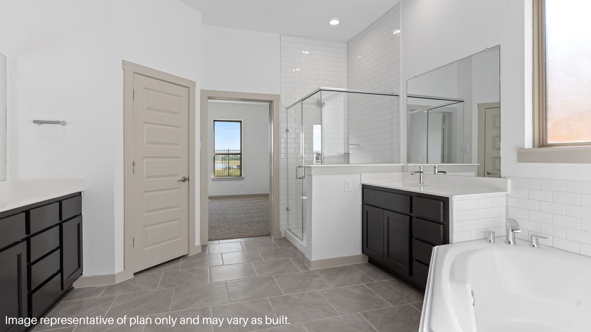 Primary bathroom with a tub, two separate sinks, a standing shower with a glass door, and a frosted window.