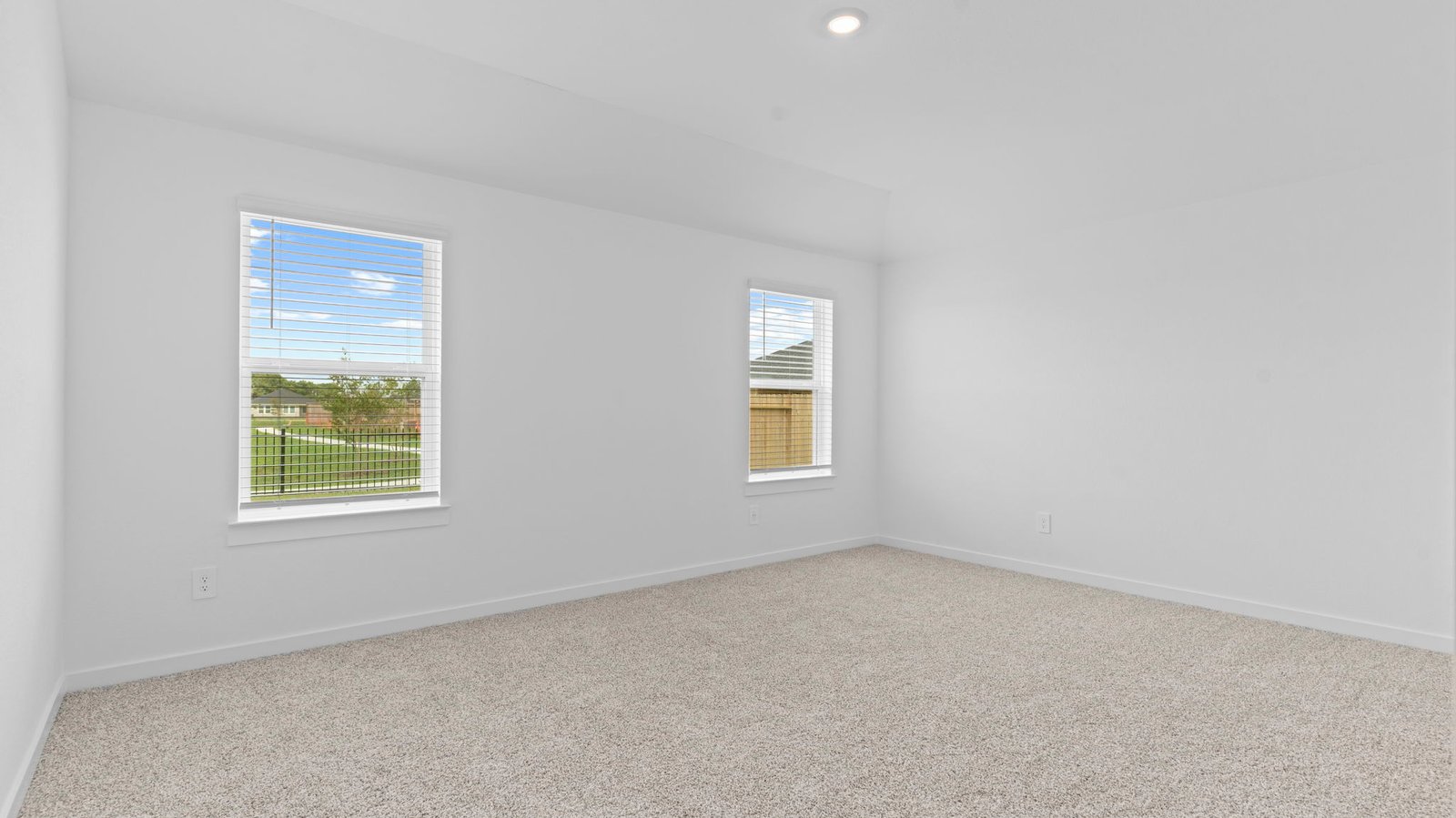 bedroom with beige carpet, white walls and a window