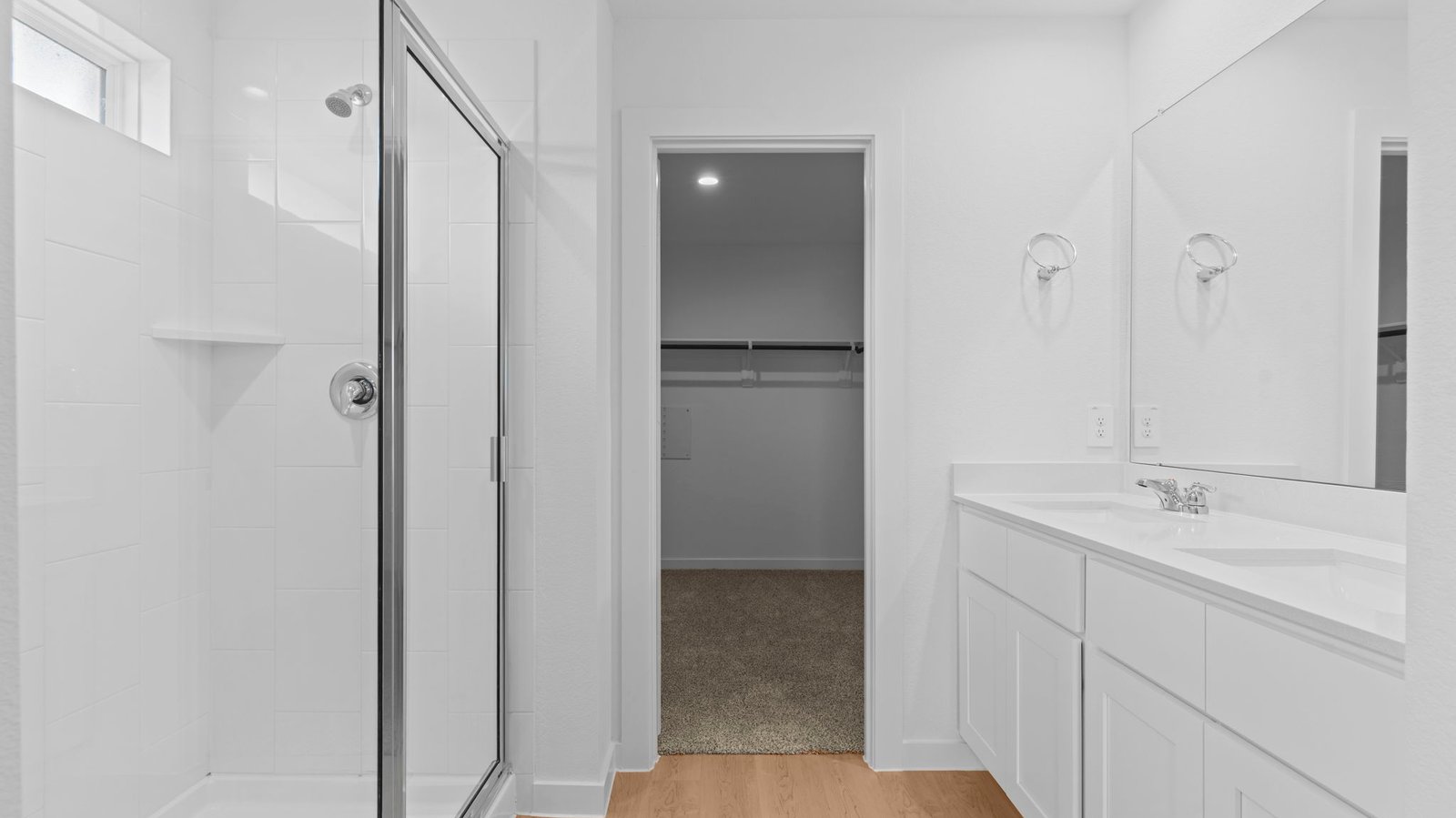 bathroom with dual vanity sinks, toilet, and a walk in shower