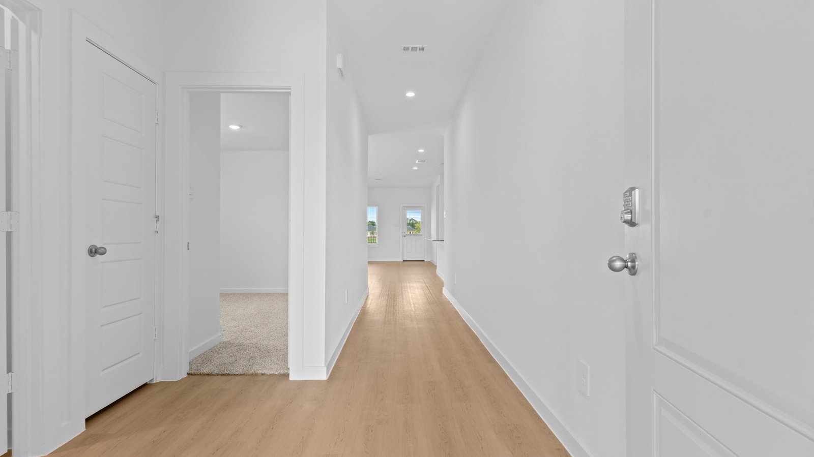 front entry way of home featuring brown flooring and white walls