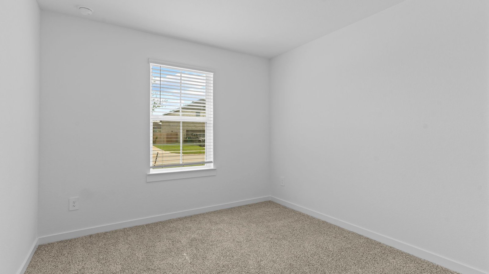 bedroom with beige carpet, white walls and a window