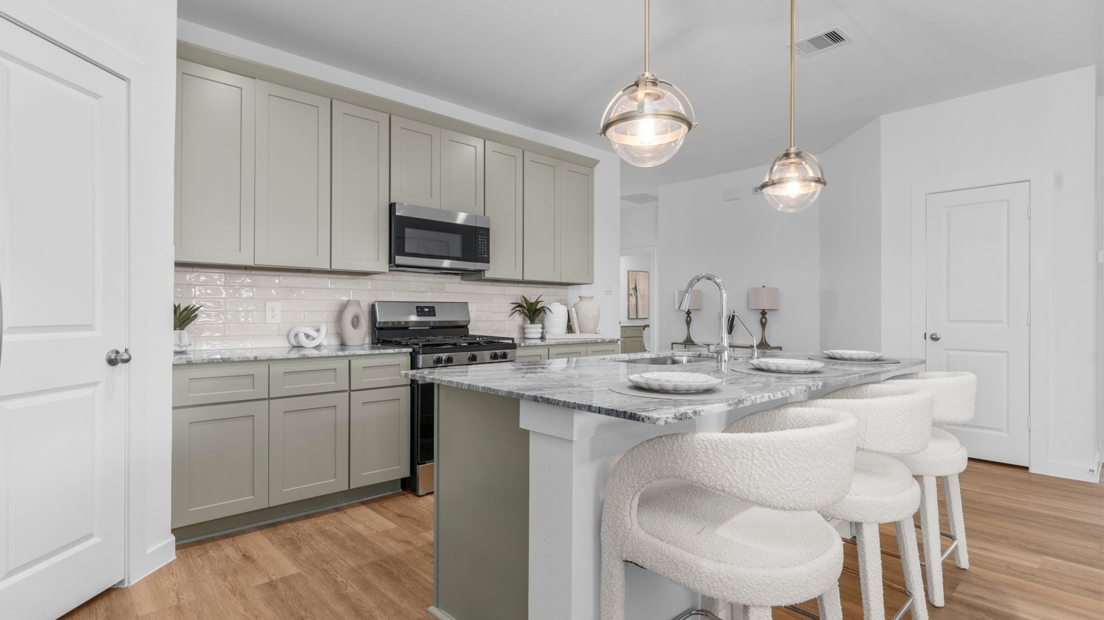 Bright and spacious kitchen with quartz countertops, stainless steel appliances, and an island with bar seating.
