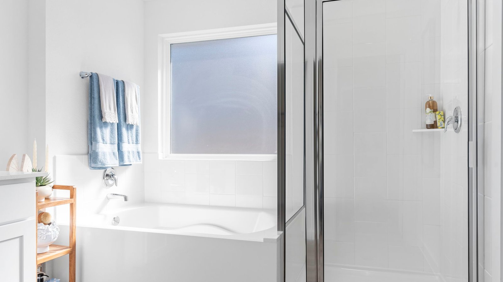 Modern primary bathroom with double vanities, quartz countertops, and a glass-enclosed shower with a walk-in closet.