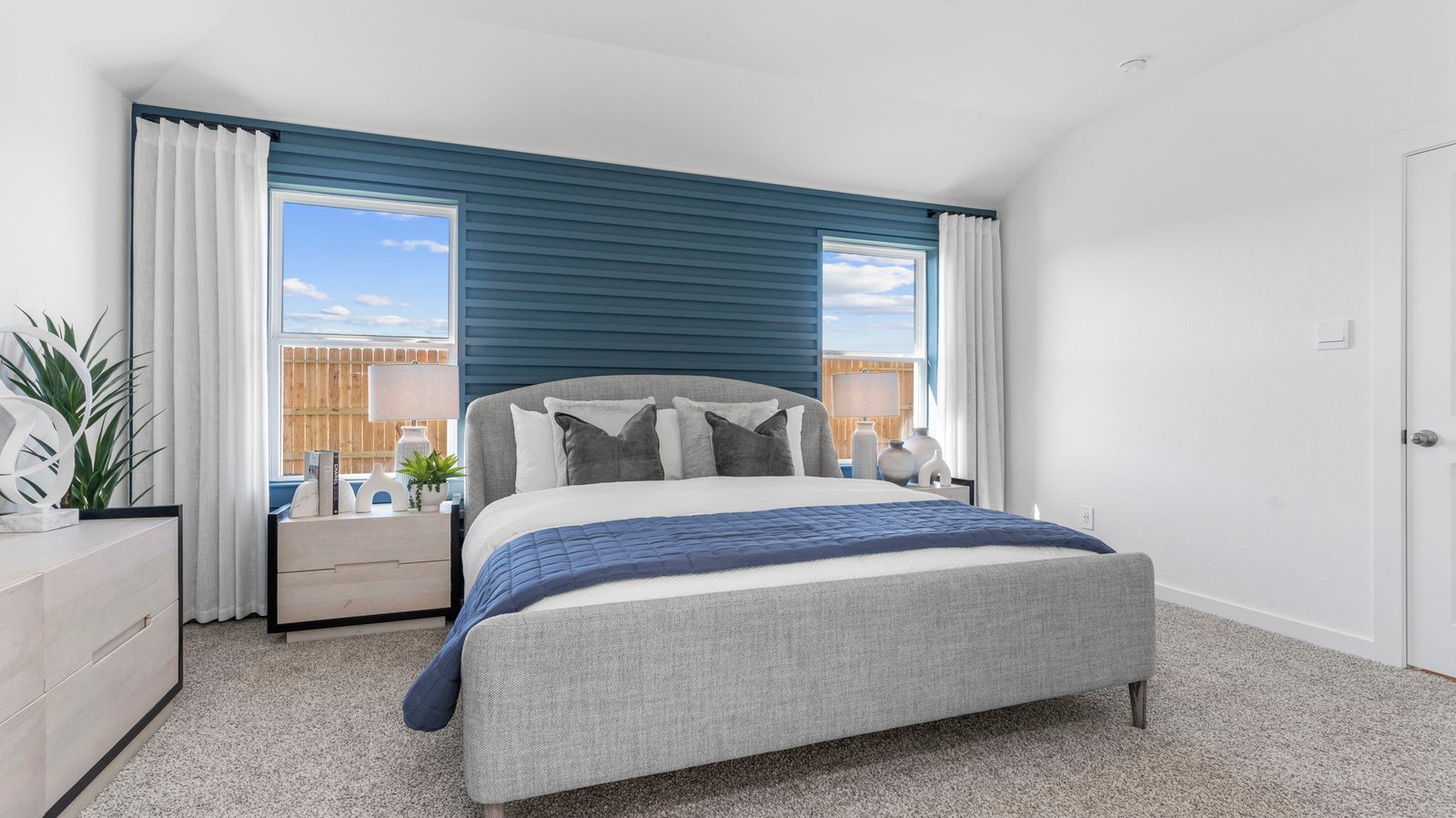 A spacious primary bedroom emphasizing open space and natural lighting with large windows.