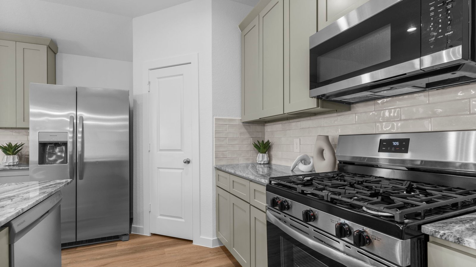Bright and spacious kitchen with quartz countertops, stainless steel appliances, and an island with bar seating.