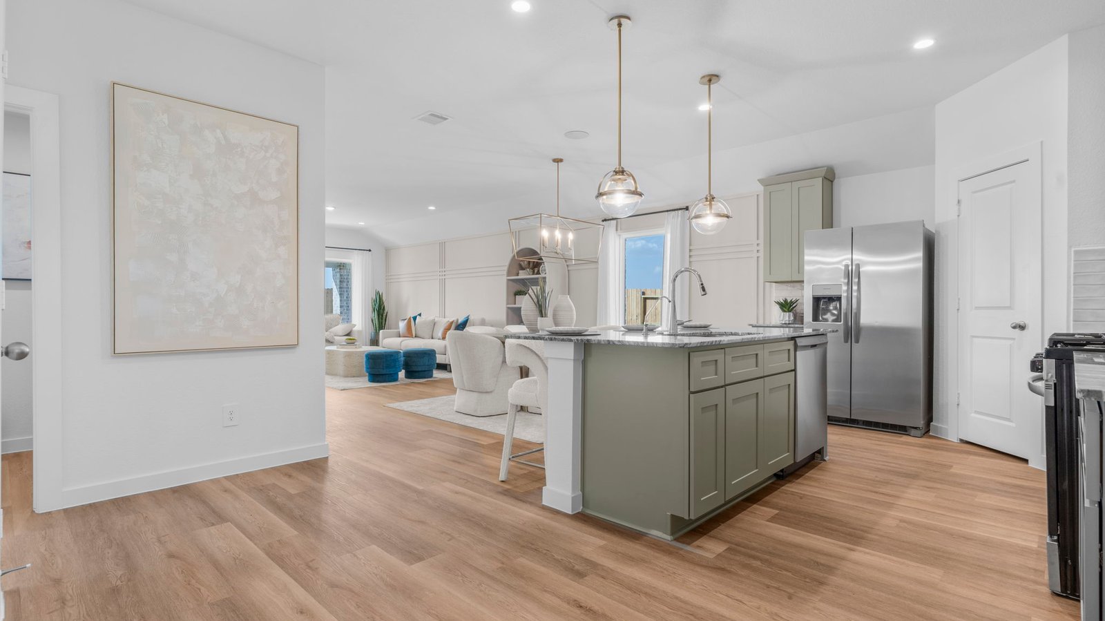 An open concept kitchen with an island with bar seating and access to the living and dining areas.