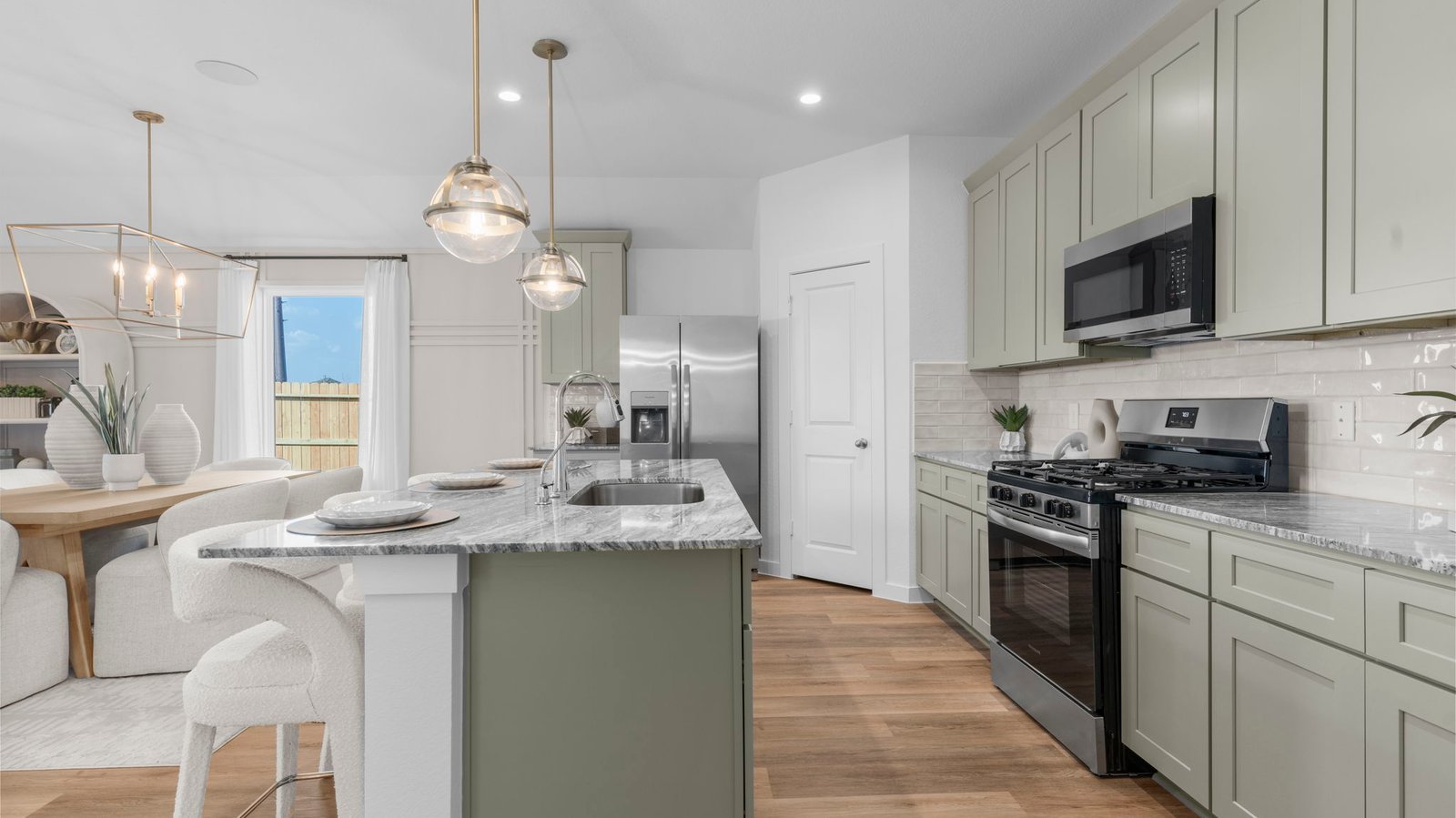 An open concept kitchen with an island with bar seating and access to the living and dining areas.