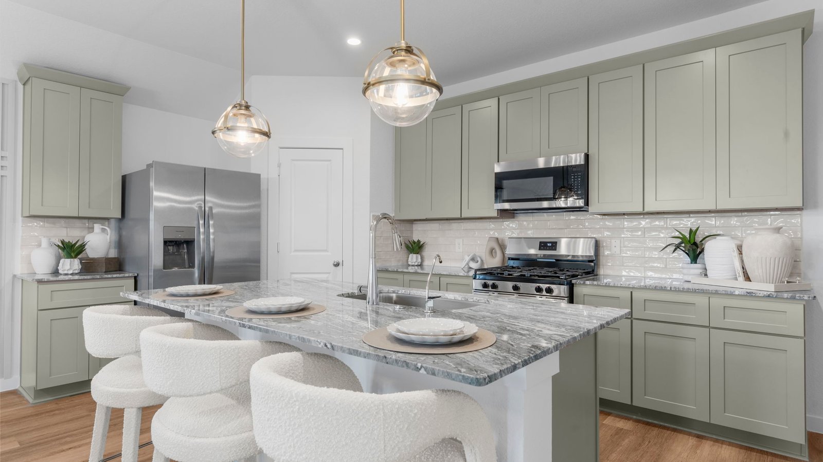 Bright and spacious kitchen with quartz countertops, stainless steel appliances, and an island with bar seating.