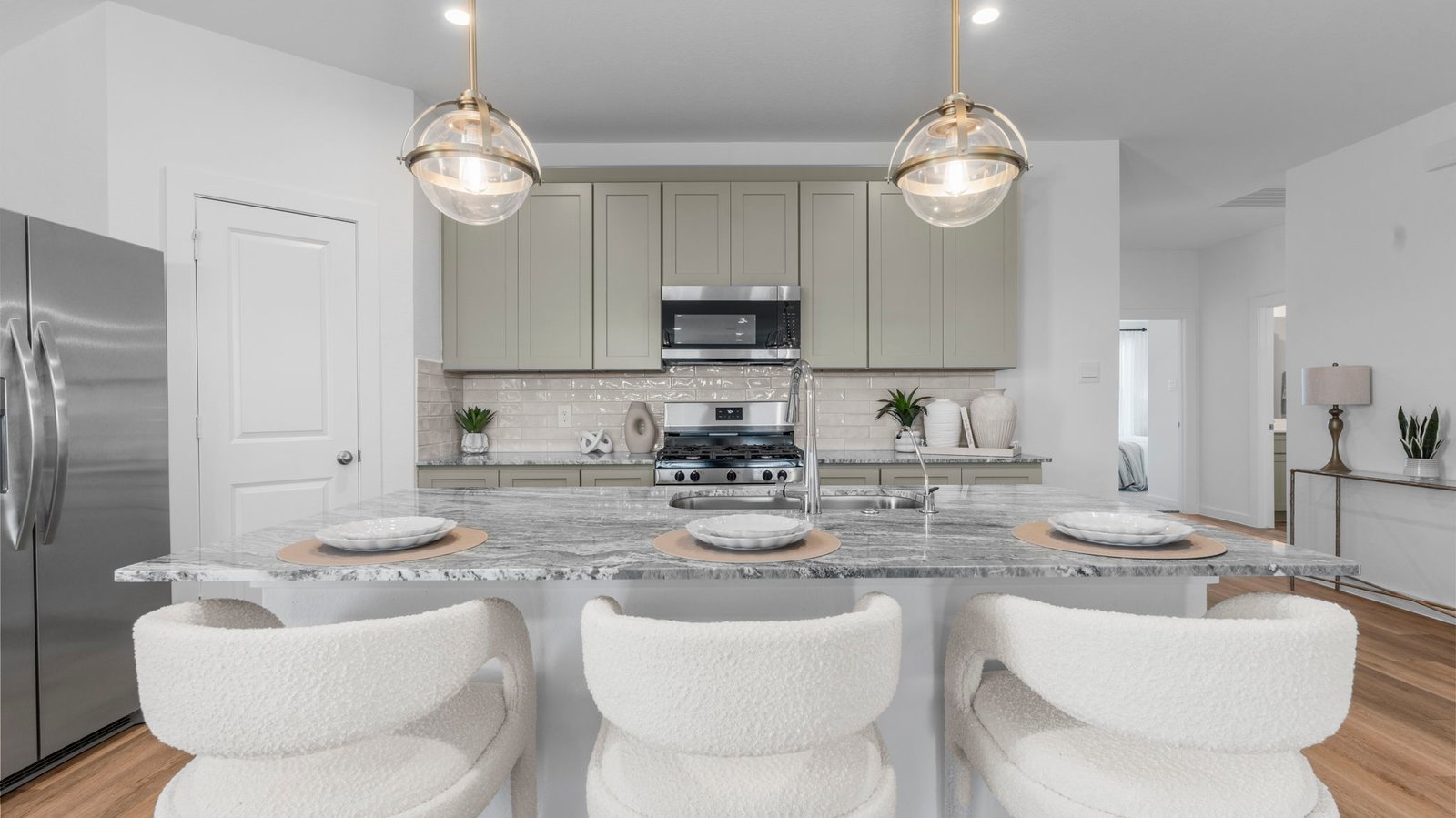 Bright and spacious kitchen with quartz countertops, stainless steel appliances, and an island with bar seating.