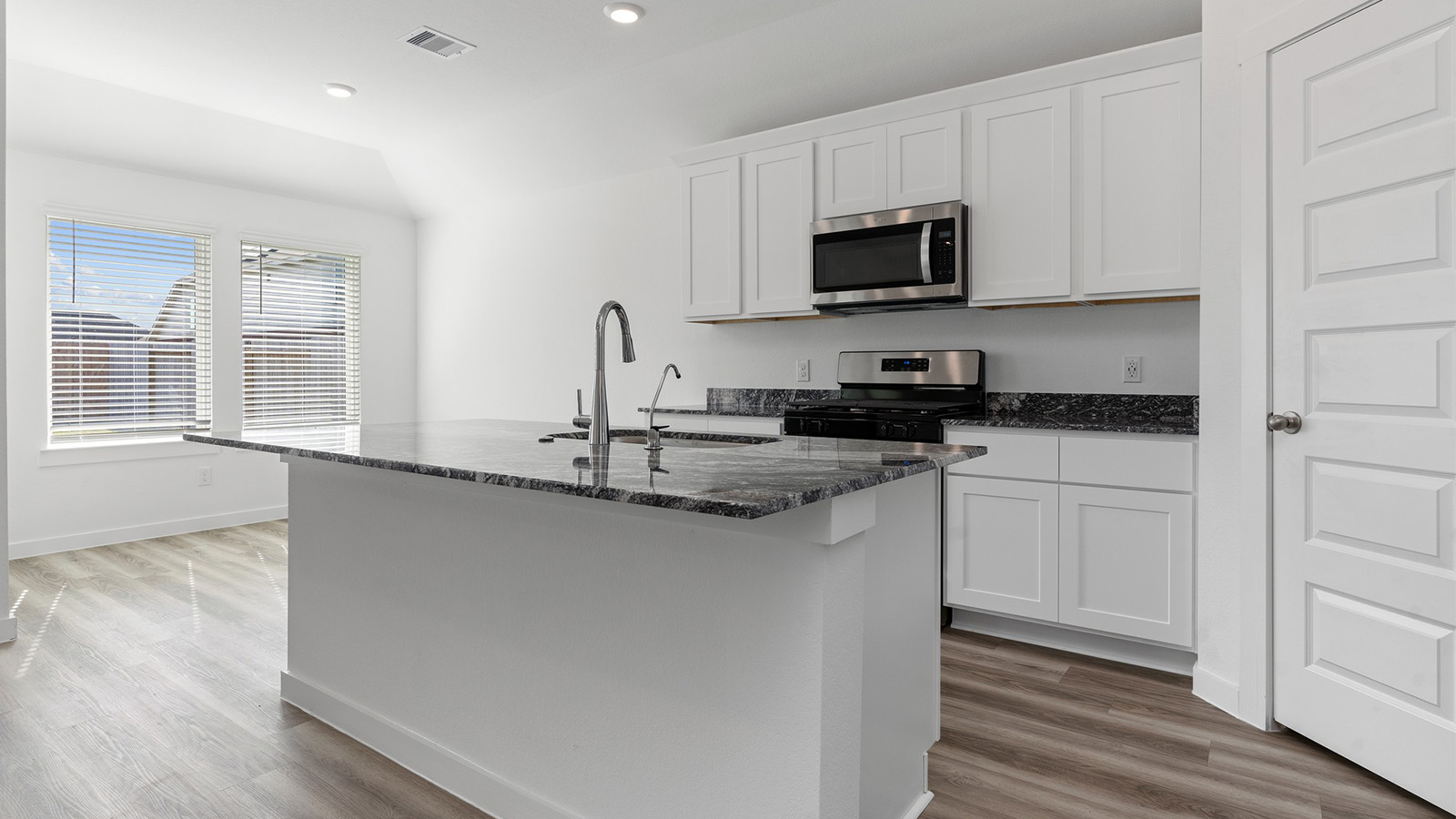 Open concept kitchen and dining room with two large windows