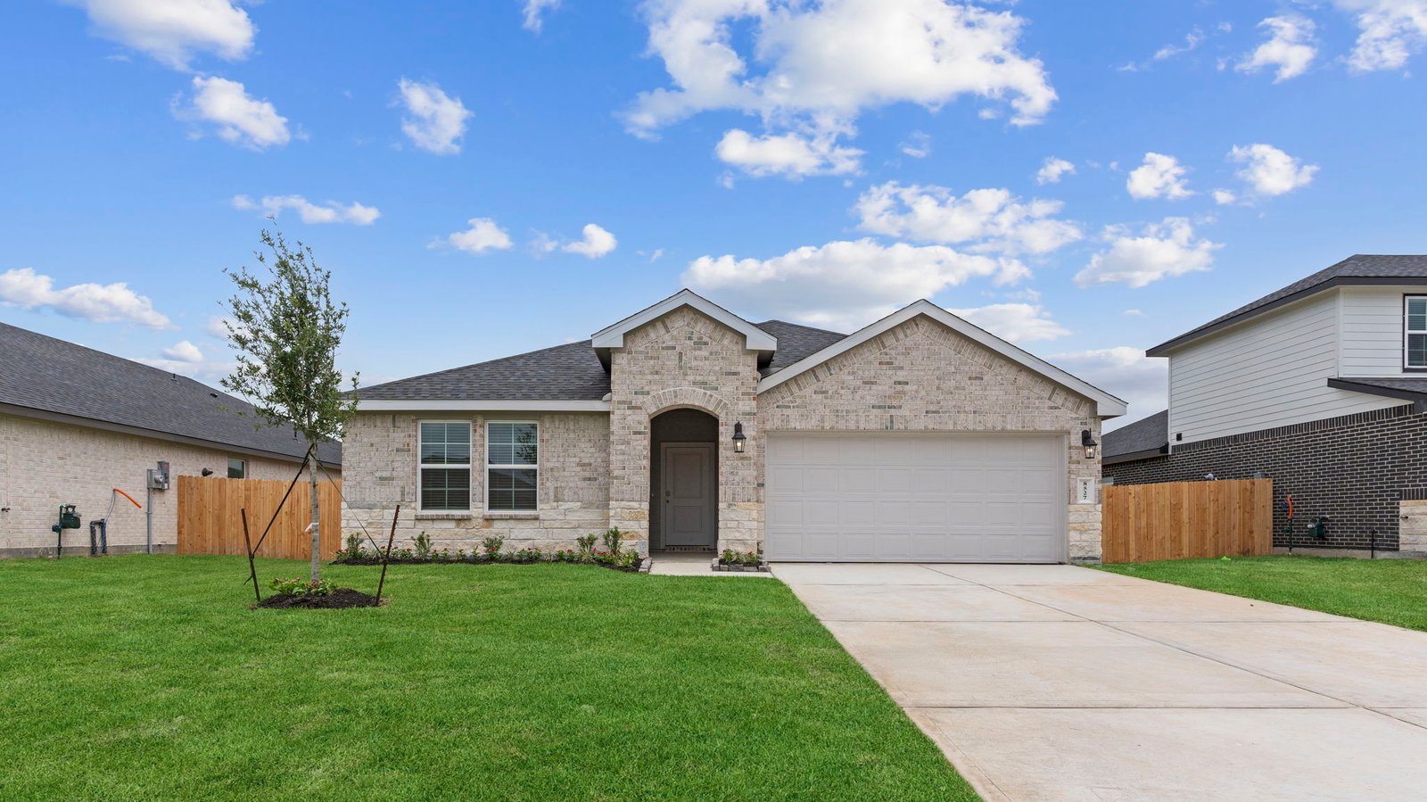Newly built single story home with traditional architecture, a double garage, and landscaped front yard.