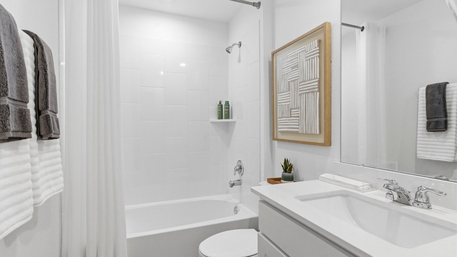 A well-designed bathroom equipped with quartz countertops, a standing tub, and a single vanity.