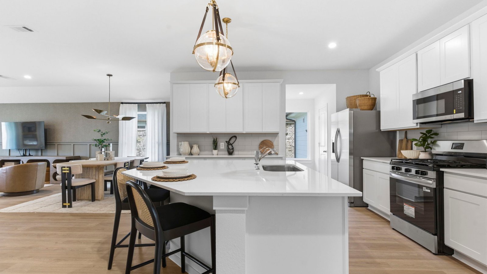 An open concept kitchen with an island with bar seating and access to the living and dining areas.
