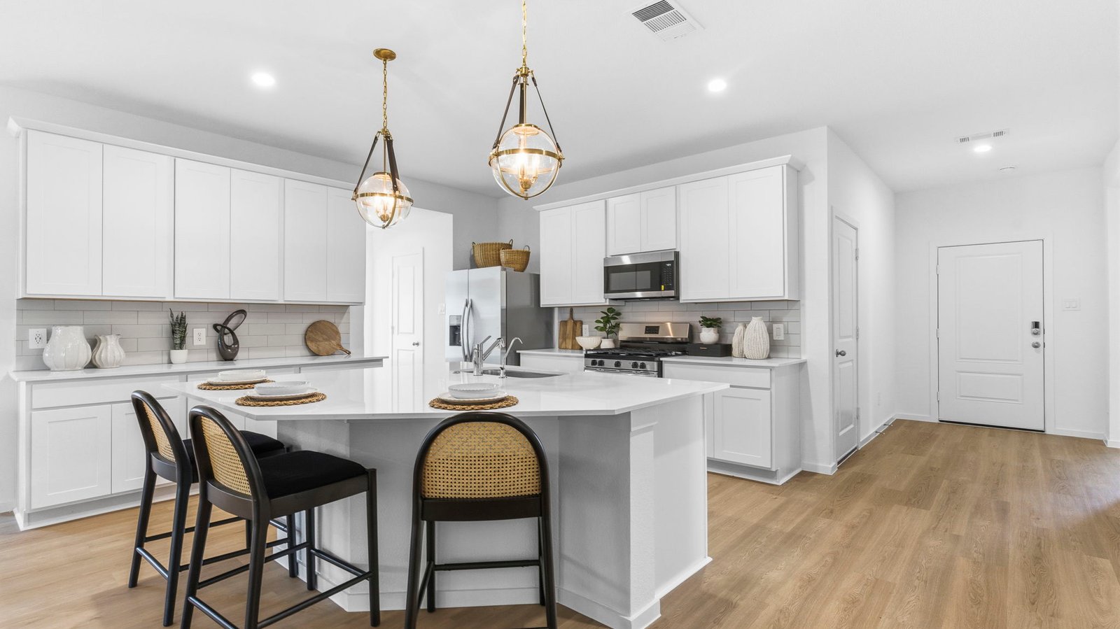 Bright and spacious kitchen with granite countertops, stainless steel appliances, and an island with bar seating.