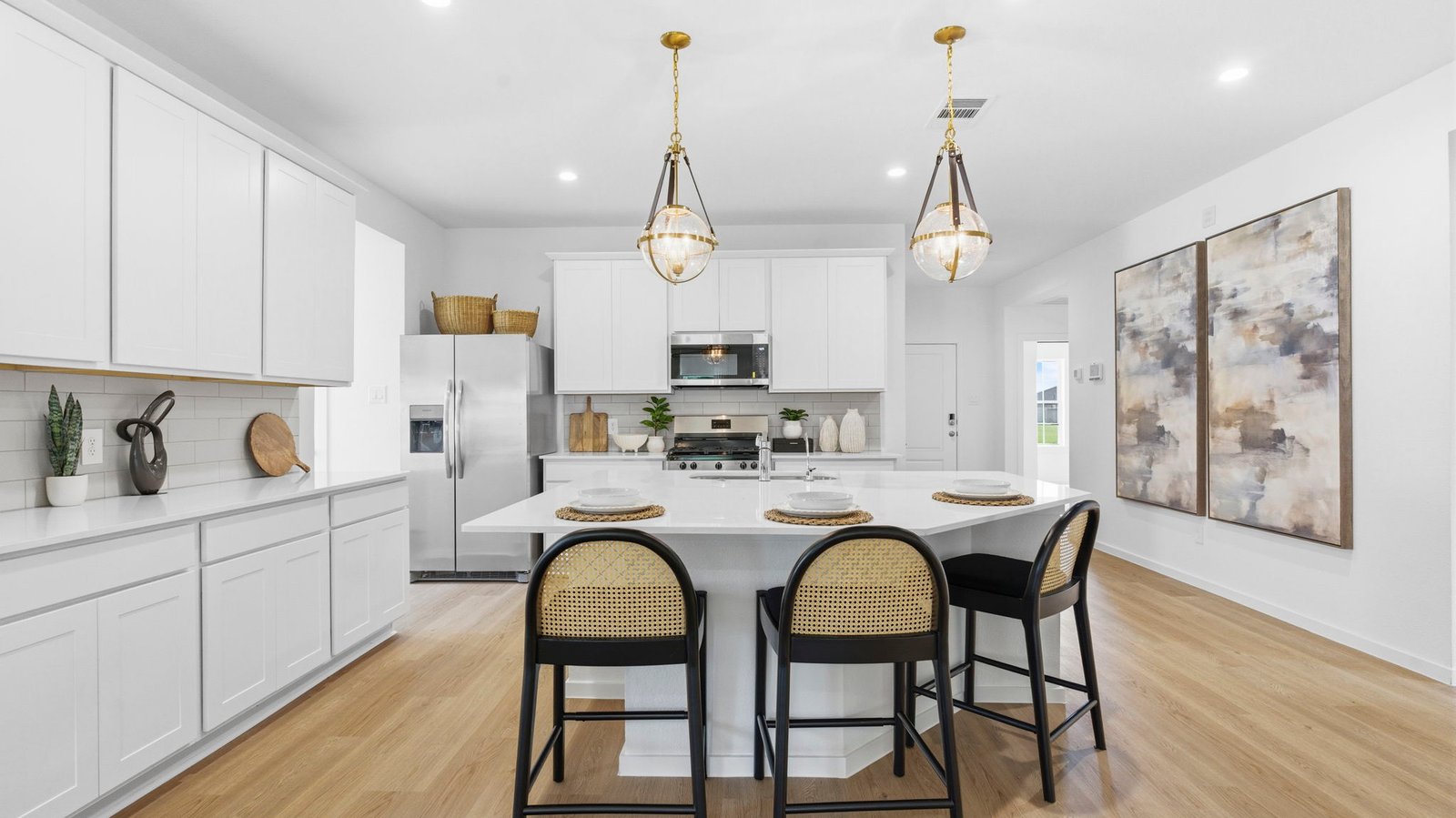 An open concept kitchen with an island with bar seating and access to the living and dining areas.