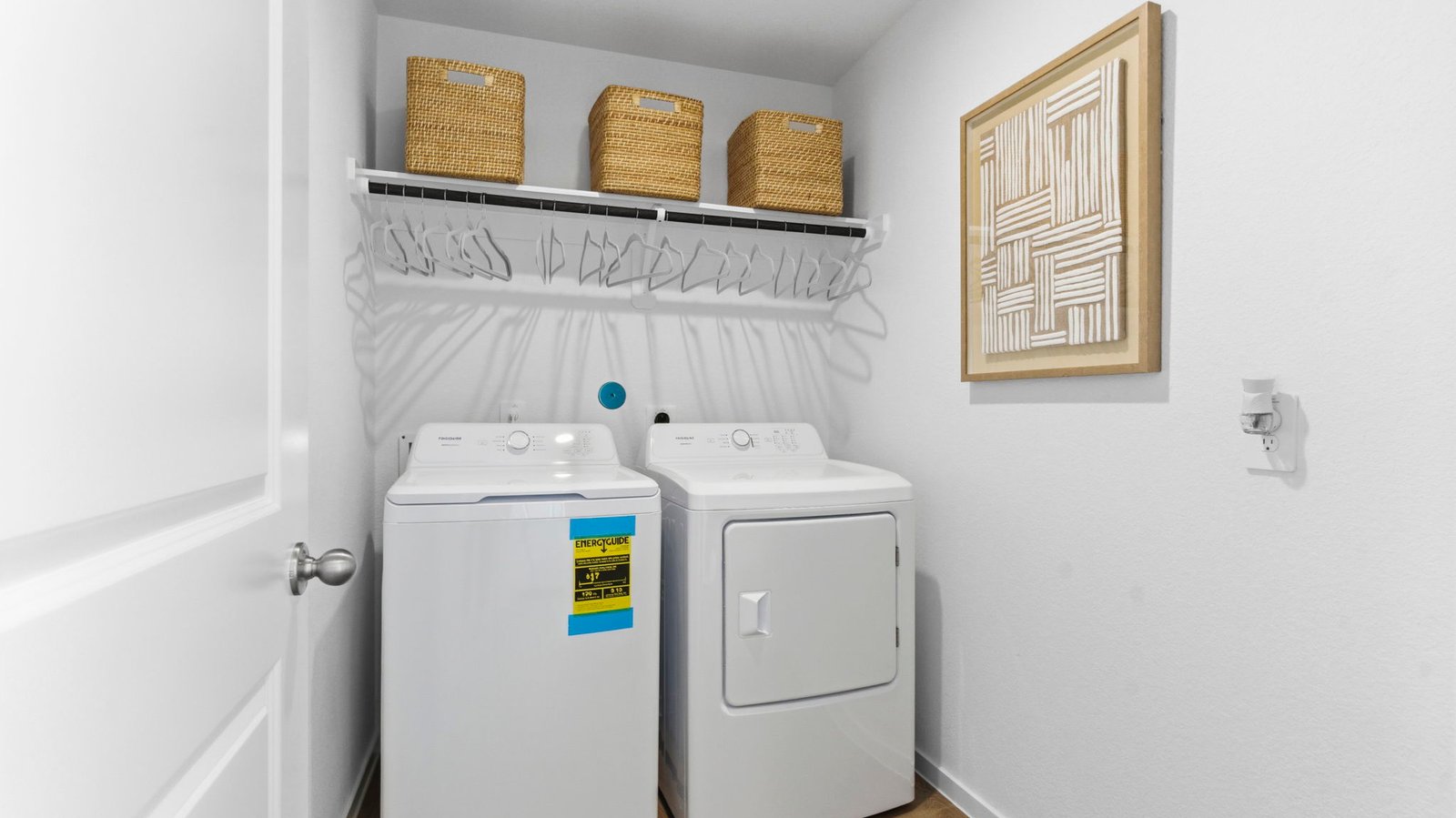 A laundry room featuring a washer and dryer, neatly arranged with ample space for laundry tasks and storage.