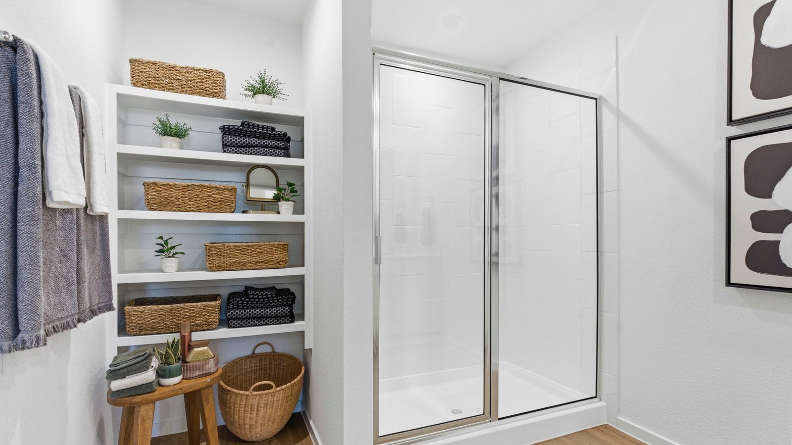 Modern primary bathroom with double vanities, quartz countertops, and a glass-enclosed shower with a walk-in closet.