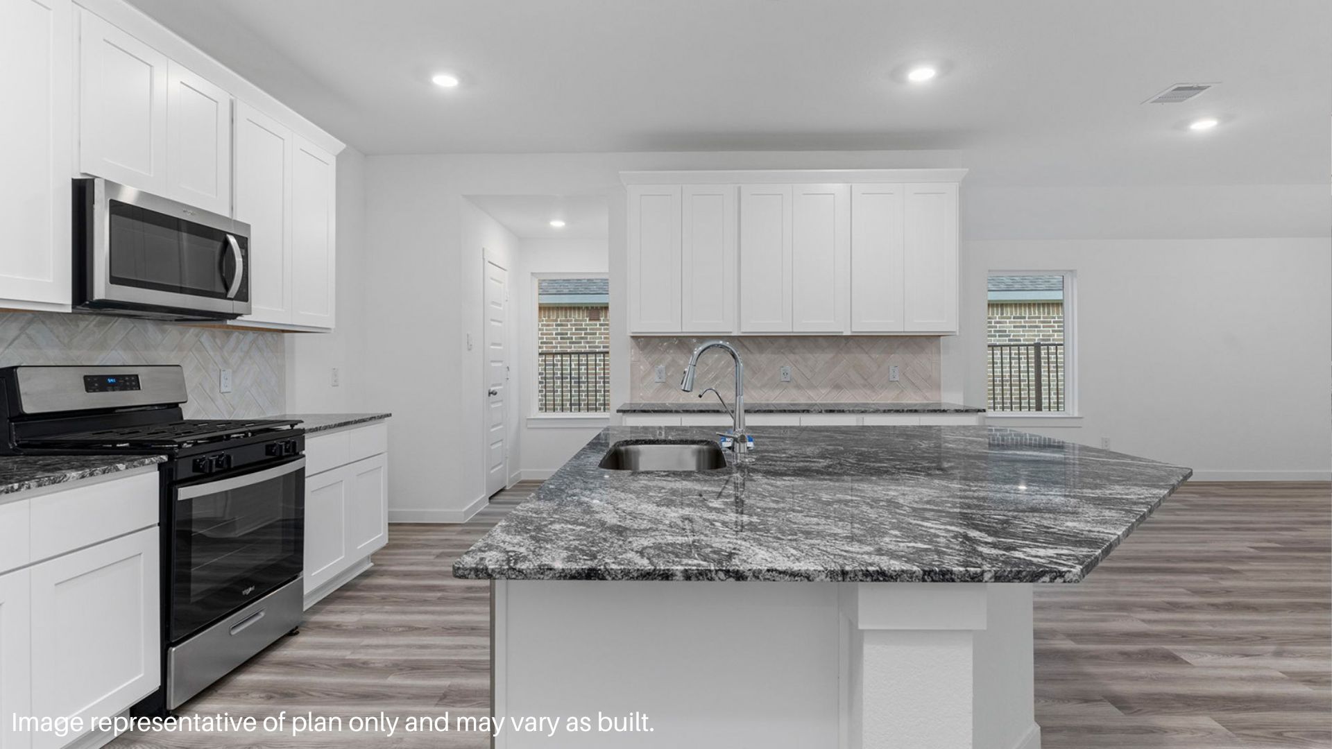 Spacious kitchen with island and stainless-steel appliances.