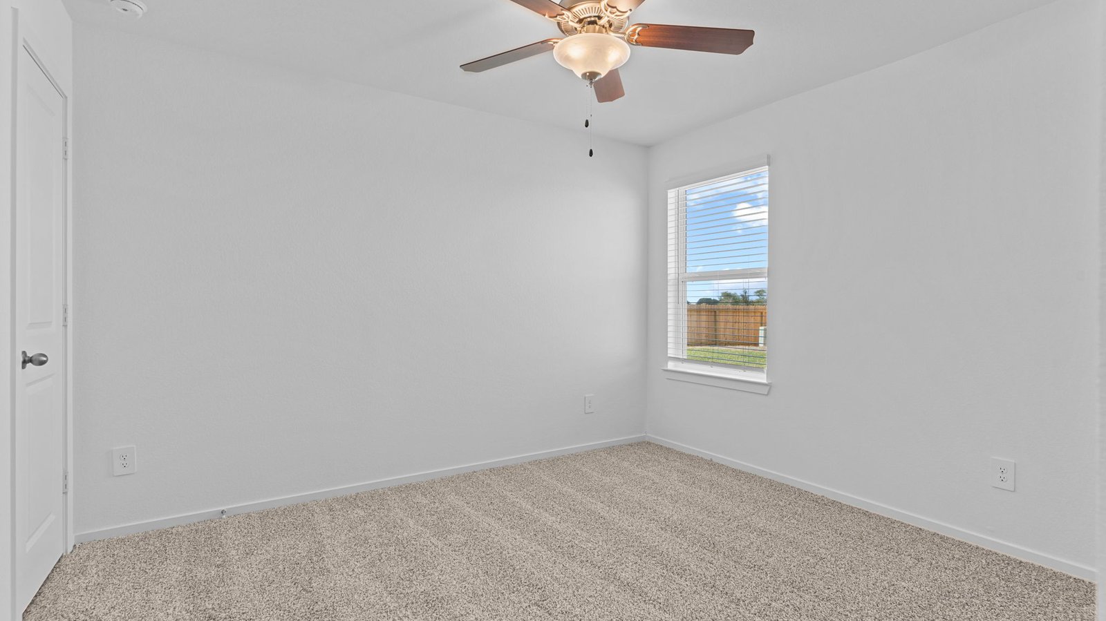 Comfortable guest bedroom featuring neutral-toned walls, carpeted flooring, and a separate closet.
