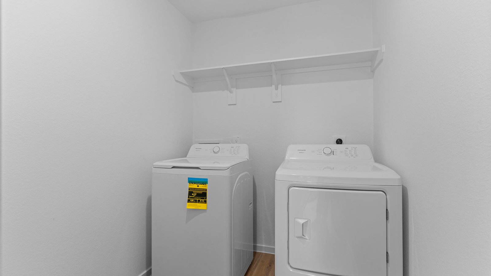 A laundry room featuring a washer and dryer, neatly arranged with ample space for laundry tasks and storage.