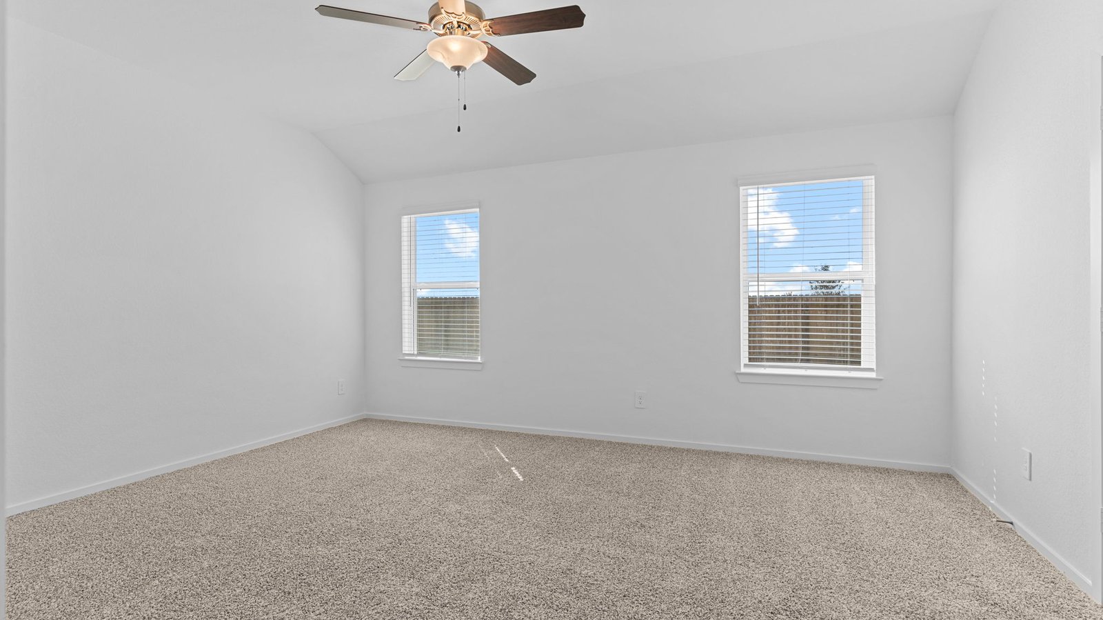 A spacious primary bedroom emphasizing open space and natural lighting with large windows.