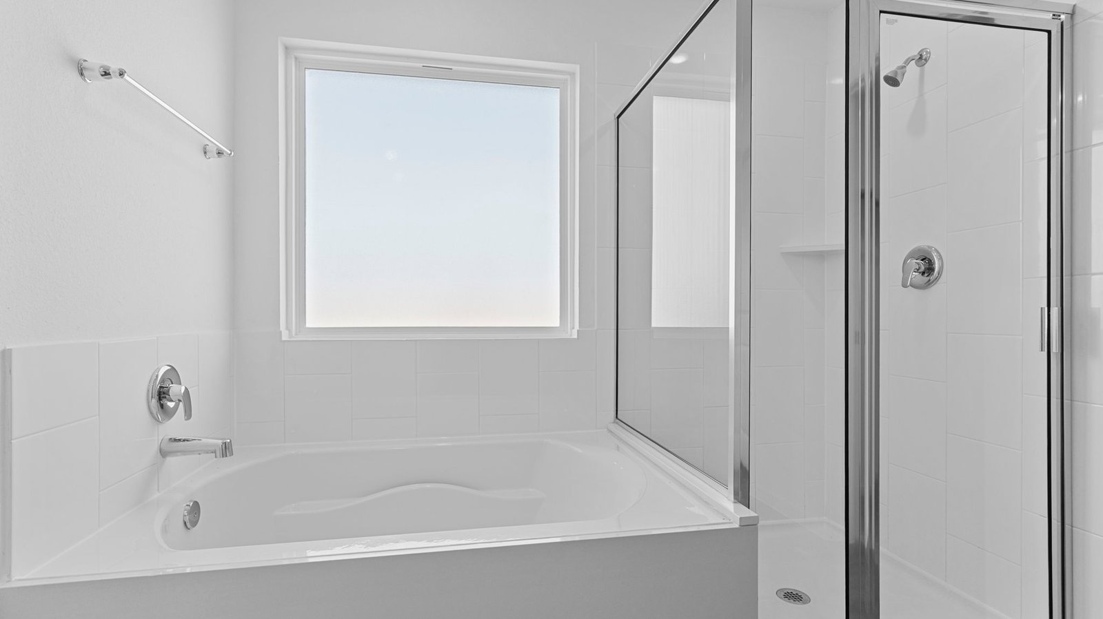 Modern primary bathroom with double vanities, quartz countertops, and a glass-enclosed shower with a walk-in closet.