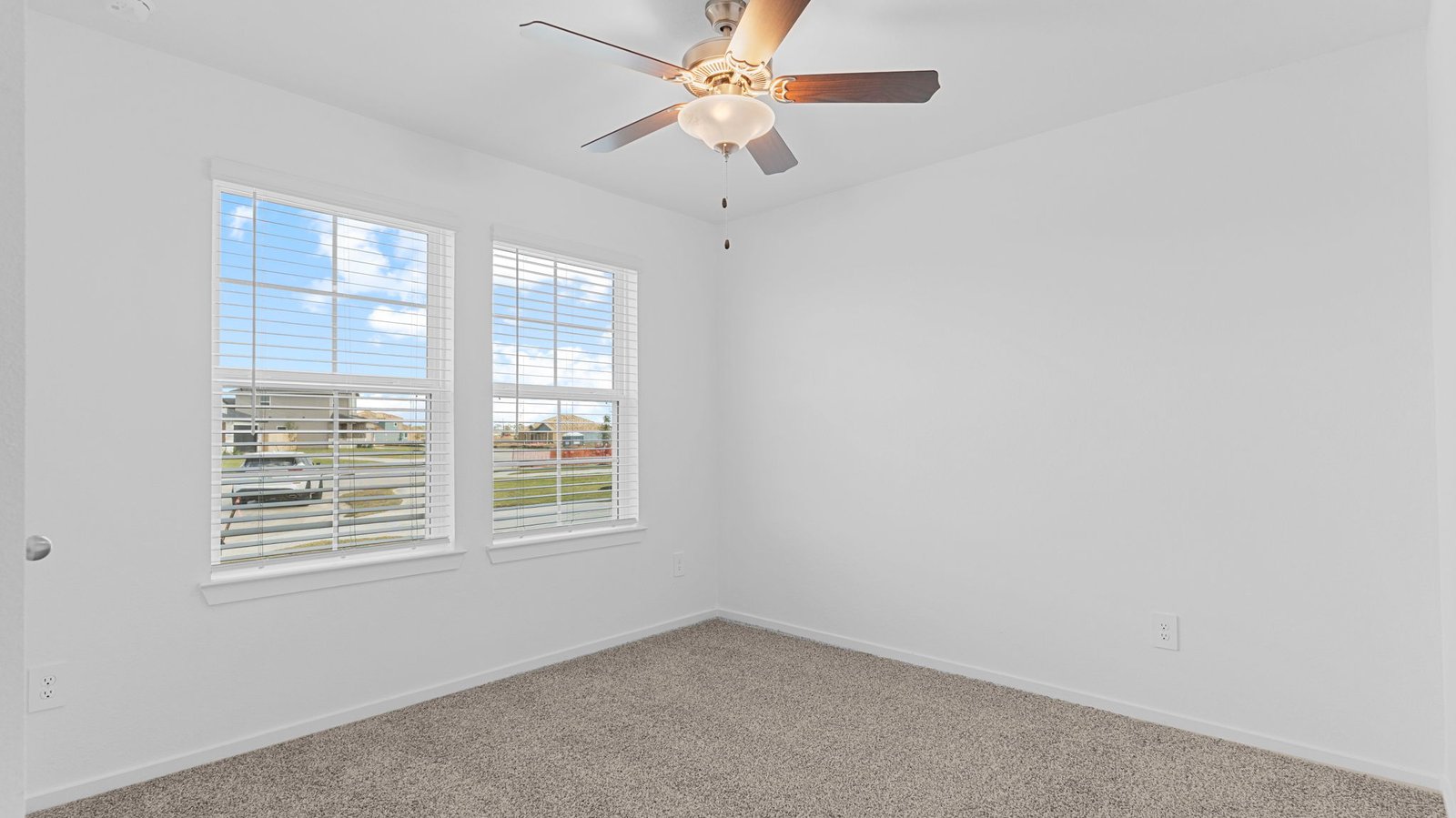 Comfortable guest bedroom featuring neutral-toned walls, carpeted flooring, and a separate closet.