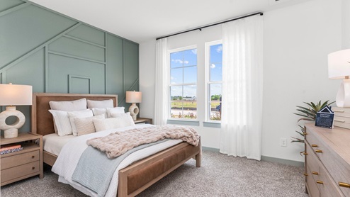 Bedroom one with carpeted floors and two large double windows for natural light.