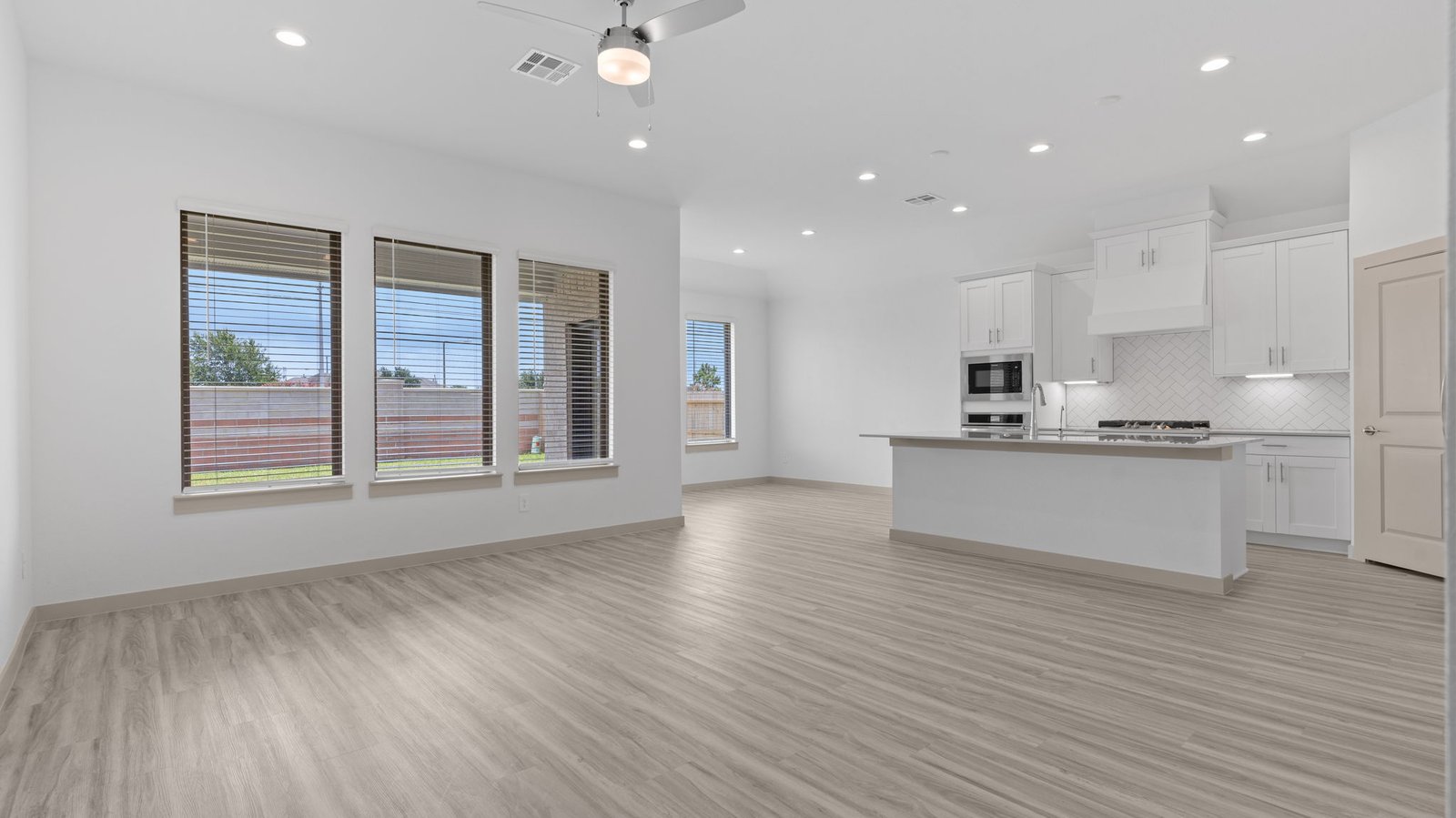 Family room has three windows, a ceiling fan, the kitchen and the breakfast /dining area.