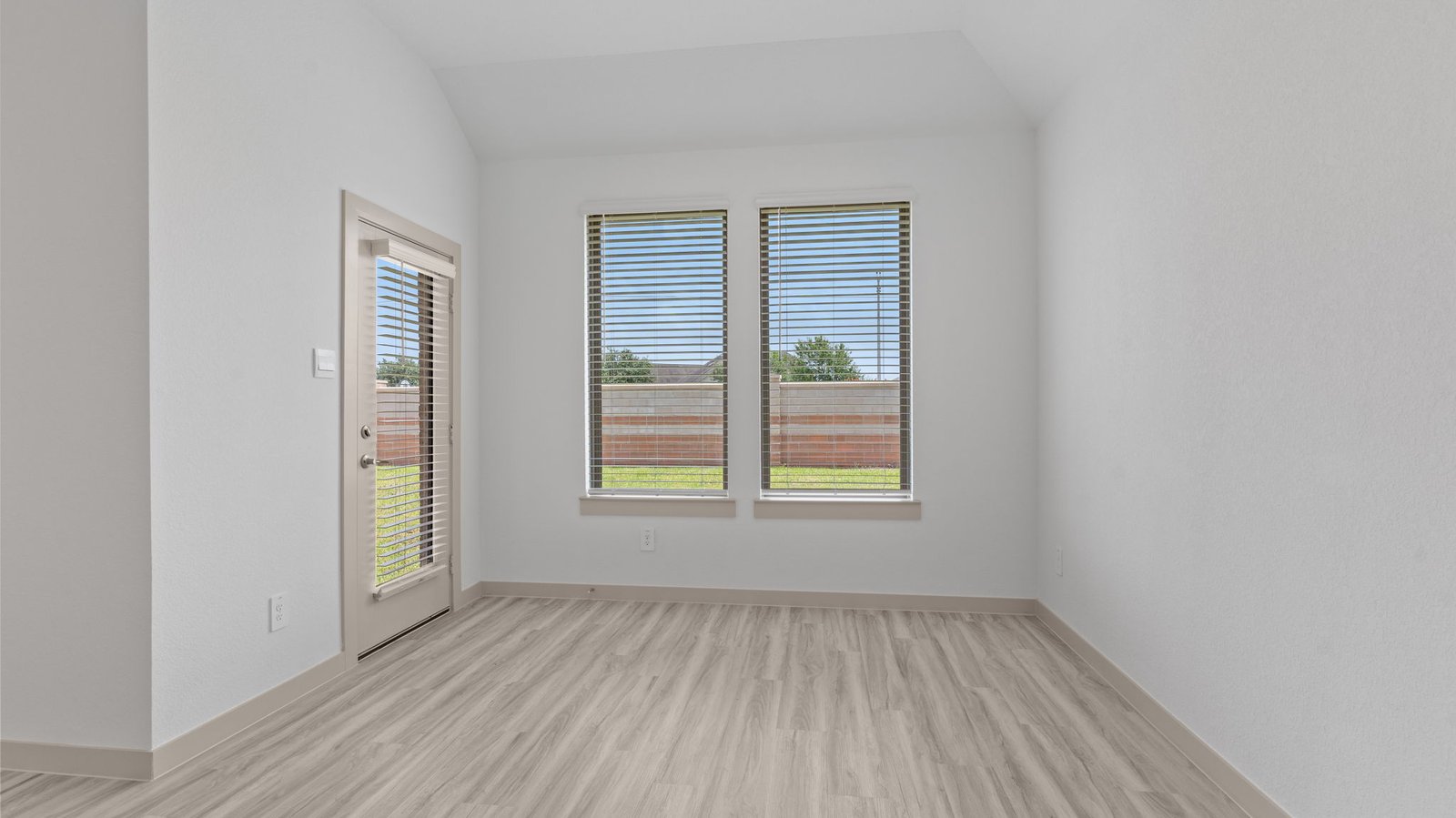 The breakfast/dining area with two windows and a glass black door.