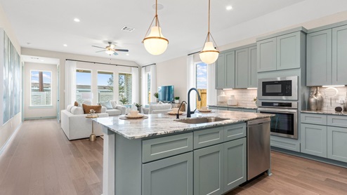 Open concept kitchen with view inside the island with the living area behind.