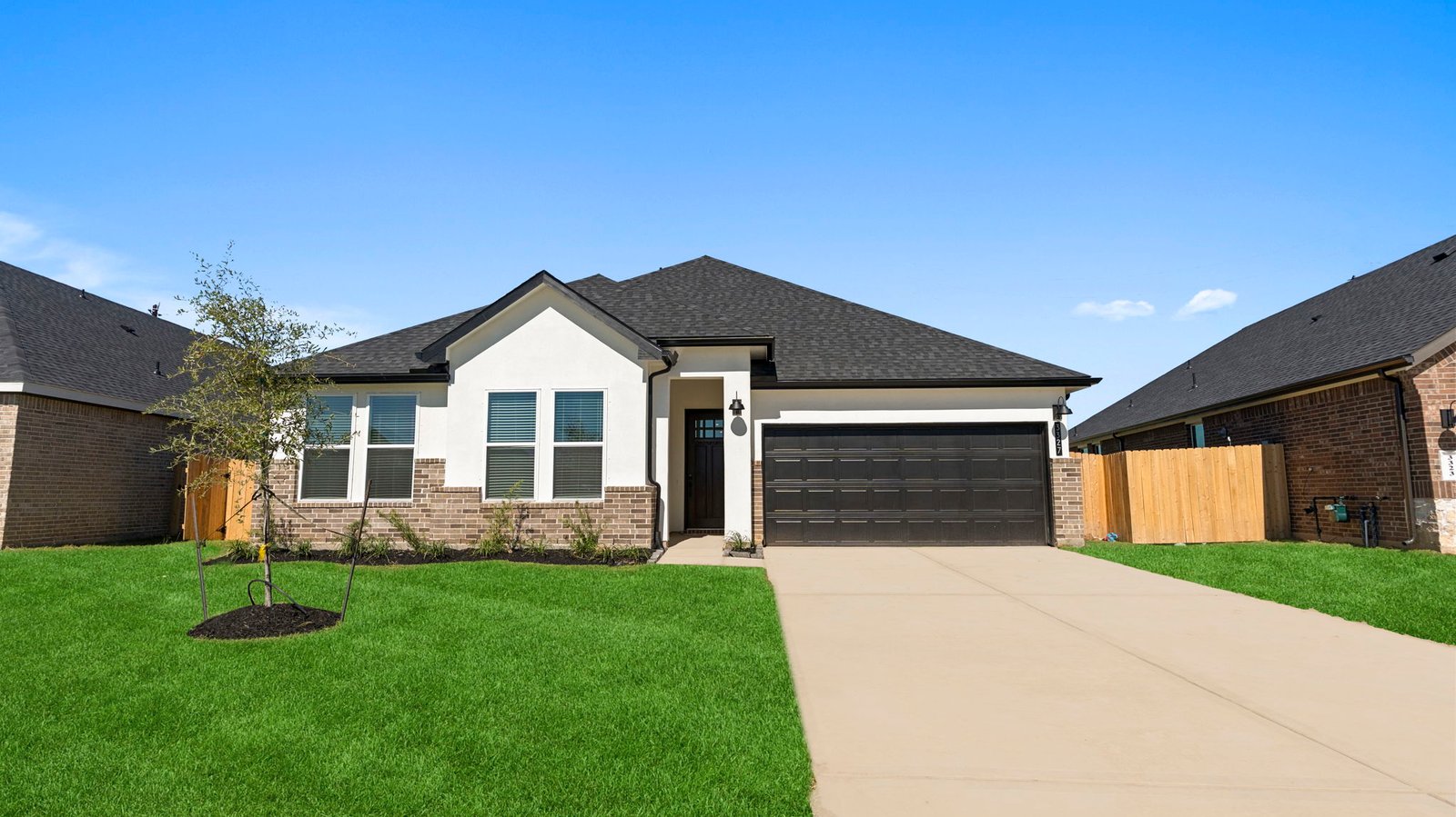 Newly built single story home with modern architecture, a double garage, and landscaped front yard.