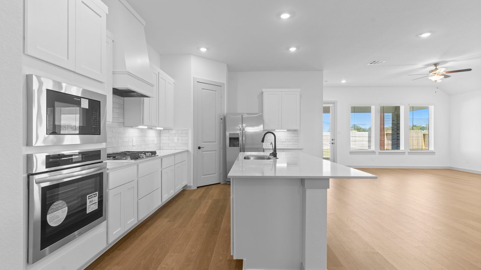 An open concept kitchen with an island with bar seating and access to the living and dining areas.