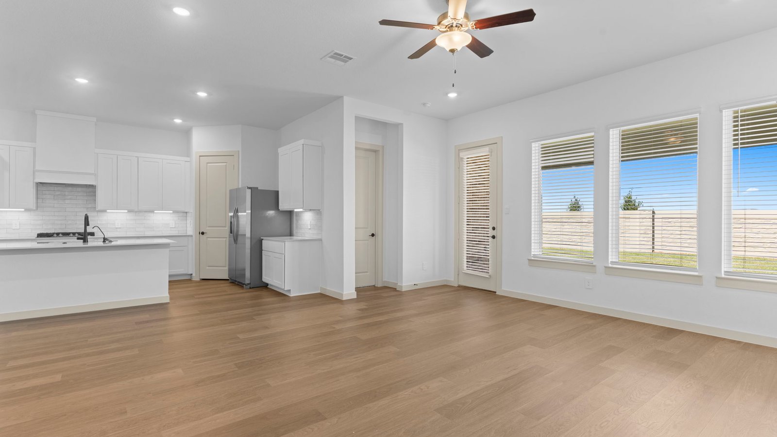 open concept kitchen and living room with three large windows