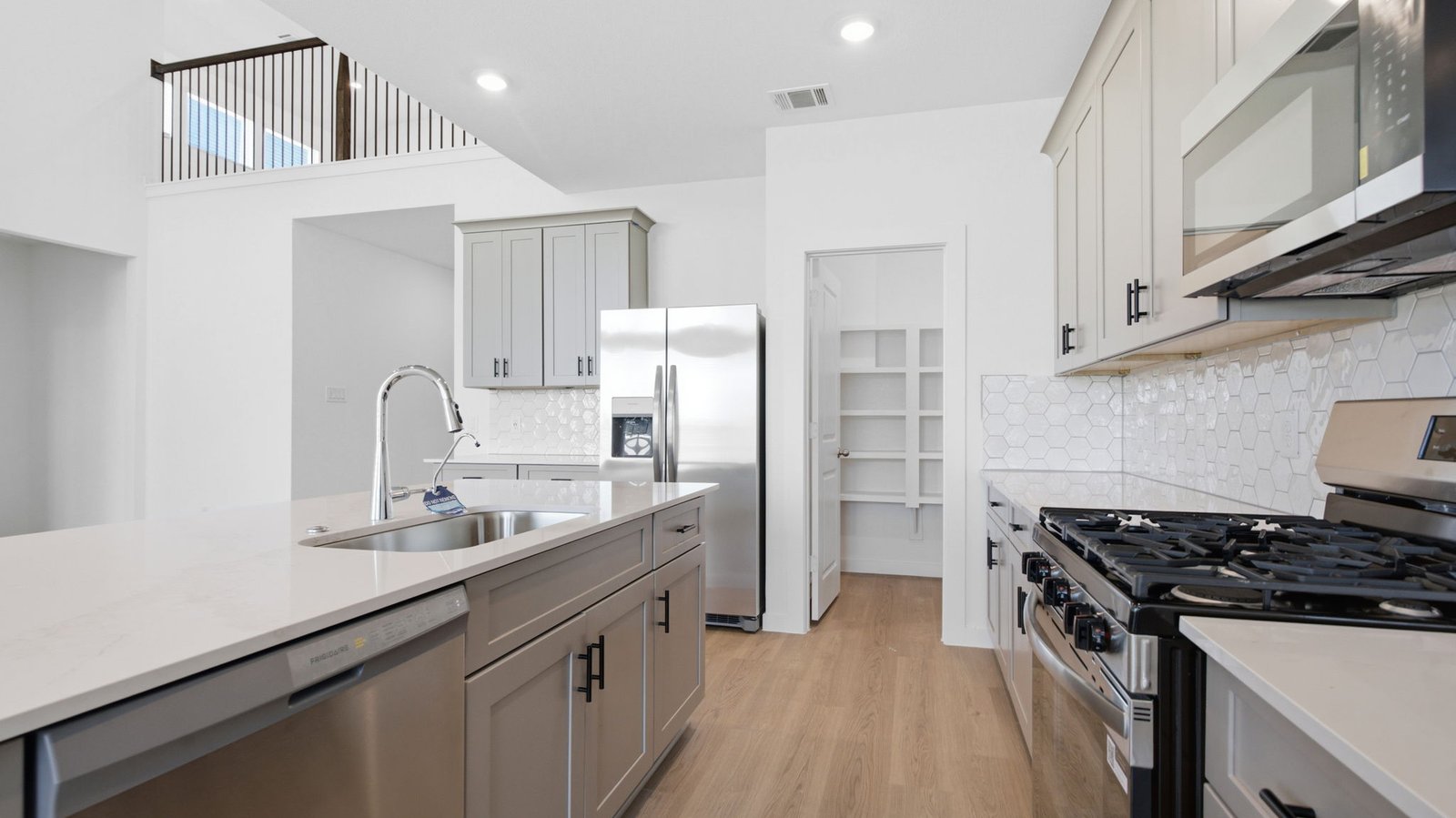 Bright and spacious kitchen with quartz countertops, stainless steel appliances, and an island with bar seating.