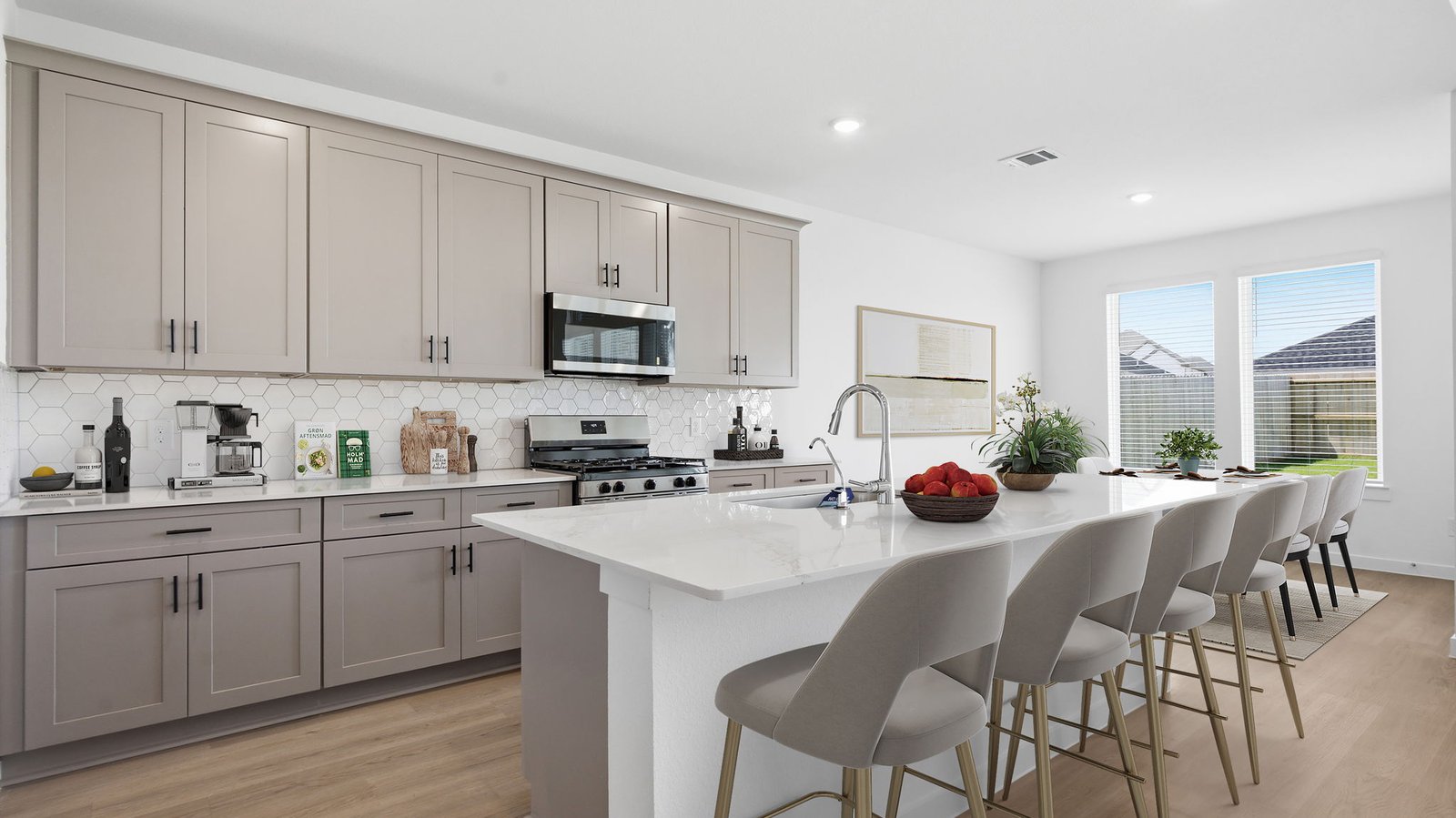 Bright and spacious kitchen with quartz countertops, stainless steel appliances, and an island with bar seating.