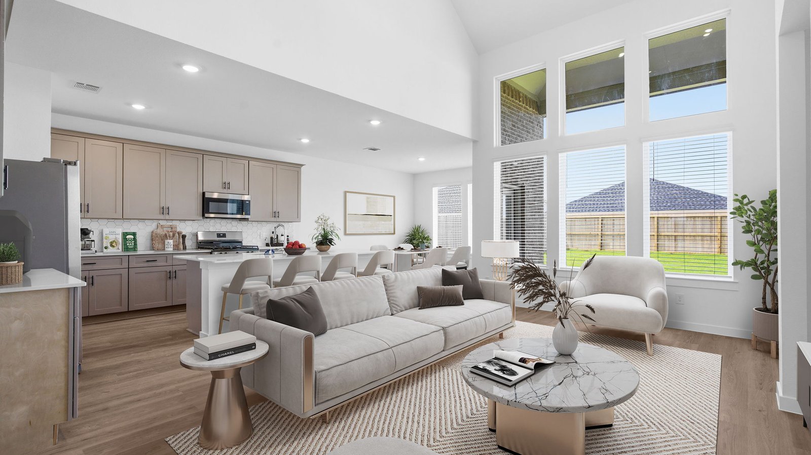A luxurious living room featuring tall ceilings, large windows for natural lighting wood flooring and a view to the backyard.