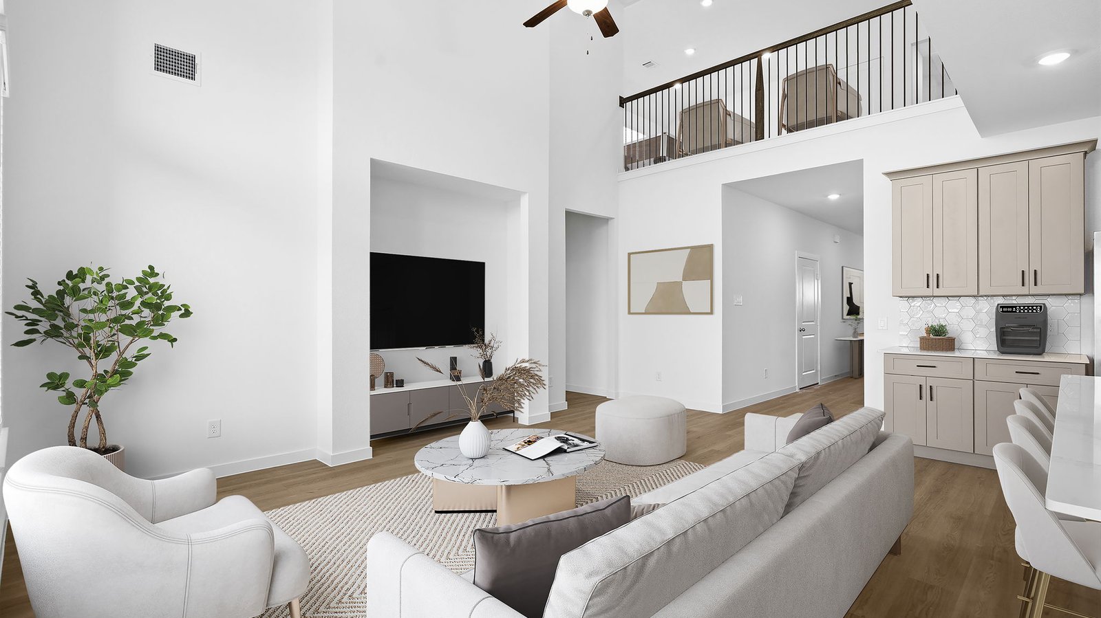 A luxurious living room featuring tall ceilings, large windows for natural lighting wood flooring and a view to the backyard.